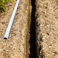 Plastic conduit ready to be installed in the trench